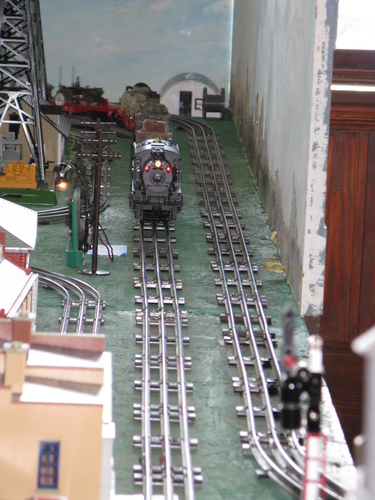 A model train turns the corner, carrying war material.