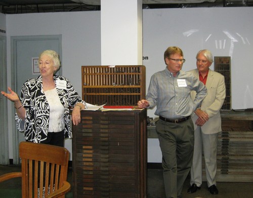  Curator Ann Roznovsky was the emcee. The exhibit recreates the experience of walking through the print shop in Alto. On the right are Trib owners Cordon Robinson and his father, Gordon. The swivel oak chair seen in photo was added by Mrs. Terri Gonzales.