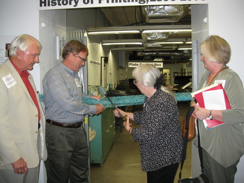  Marie Whitehead, current publisher of the Rusk Cherokeean does the honors while her daughter, editor Terri Gonzales, looks on. Clifton Robinson and his son Gordon Robinson, owners of the Waco Tribune-Herald are seen on the left.