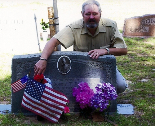 Rickey Robertson at the grave of his uncle, Sgt. Bobbie T. Robertson in Mt. Carmel Cemetery