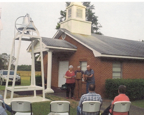 Betty and Murl Westfall, accompanied by Steve Mitchell on guitar, sing “The Old Country Church” at the dedication of the church bell at Pine Grove Baptist Church on May 26, 2012.