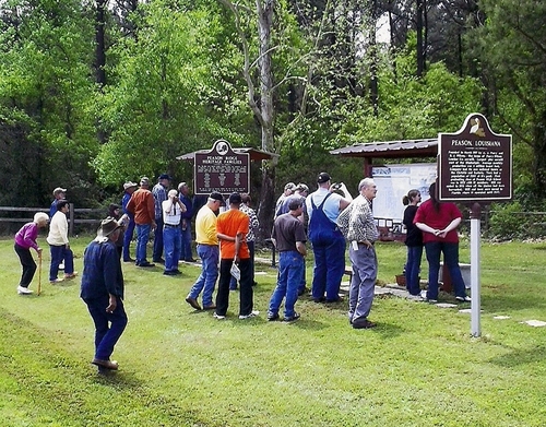 The tour group looking at the historical markers and photo kiosks at Peason Memorial Park. (Rickey Robertson Collection)