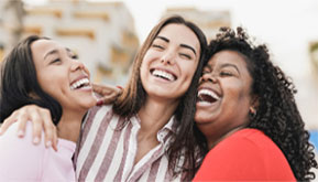 three women laughing and smiling together