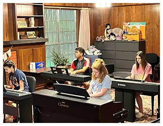 Students sitting at keyboards learning piano