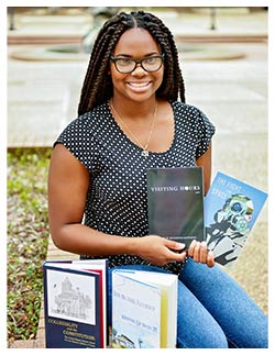 Jakayla Murphy displays books she assisted the SFA Press in publishing. As a student assistant, Murphy is able to gain hands-on experience in every part of the publication process, including designing, editing and marketing.