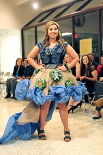 Fashion merchandising senior Karlye Fleniken of Lufkin models a dress she and Cheymar Wright, fashion merchandising senior from Fort Worth, designed using a broken umbrella, aluminum cans, tablecloths, water bottles, fake moss and recycled zippers.