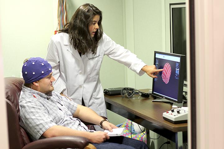 graduate students Rebecca Recio-Swift and T.J. Swift demonstrate neuro-feedback equipment in the university's Human Neuroscience Lab