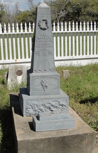 White bronze monument marking the grave of Ada Minter Jackson at the Wallis Cemetery at Wallisville. She was the first wife of Judge Hugh E. Jackson. The reverse side of the monument lists his mother Sarah Wallis Jackson.