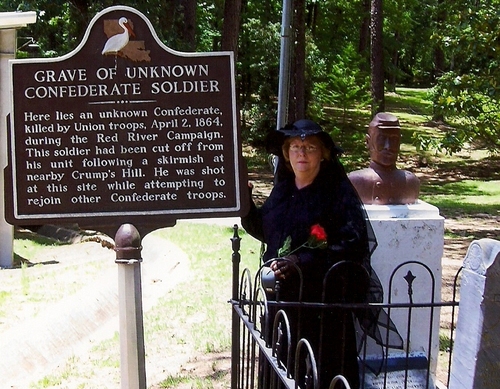 Patsy Robertson, United Daughters of the Confederacy, at the grave site and historical marker for the Unknown Confederate at Rebel State Park.