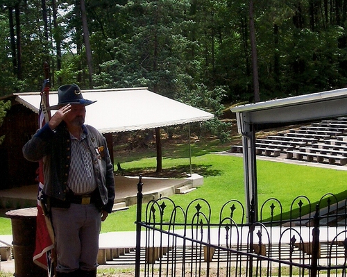Color Sergeant Rickey Robertson, Sons of Confederate Veterans, salutes while honors are being rendered to the Unknown Confederate Soldier at Rebel State Park.