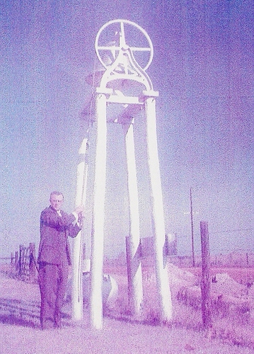 The bell pictured when it was located at the original site of Pine Grove Church. Rev. John W. Goodwin is ringing the bell.