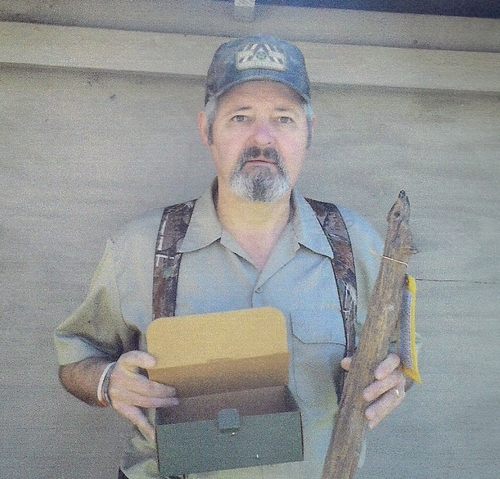 Rickey Robertson is shown holding the box all his grandfathers old veterinary tools that were used at the Peavy-Wilson Corral Site are kept and he is also holding a piece of the old fence from the