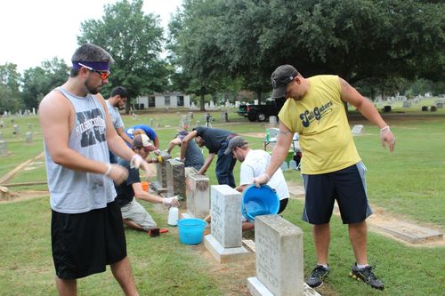 Students cleaning gravestones