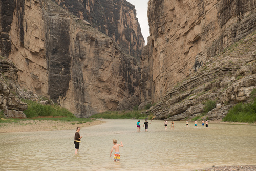 Students wade in the Rio Grande, which serves as the international border between the United States (on right) and Mexico (left).