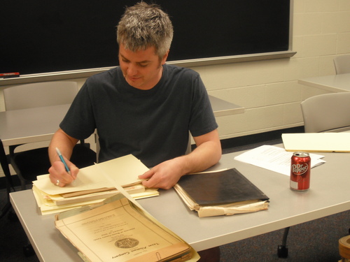 Greg Garcia examining materials from Millard's Crossing