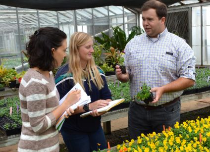 Dr. Barnes with students in greenhouse
