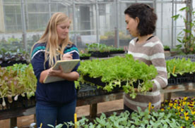 student and teacher in greenhouse