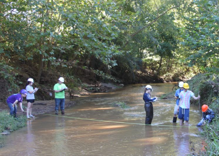 students measuring a stream