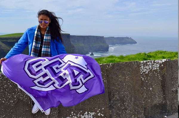 Celine Gragasin with the SFA flag studying abroad in Ireland