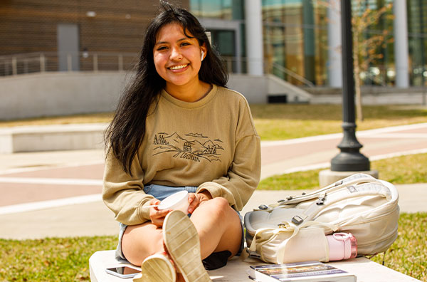 Student smiling while sitting outside