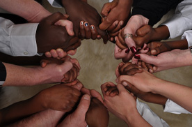 diverse group of hands holding in a circle
