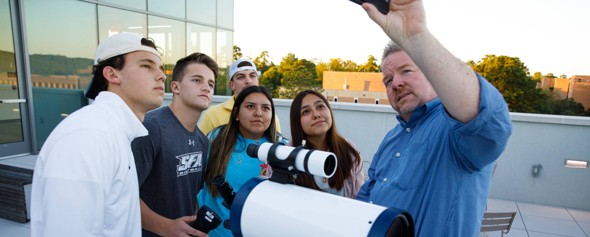 Dr. Dan Bruton demonstrates to a group of students how to use astronomy equipment