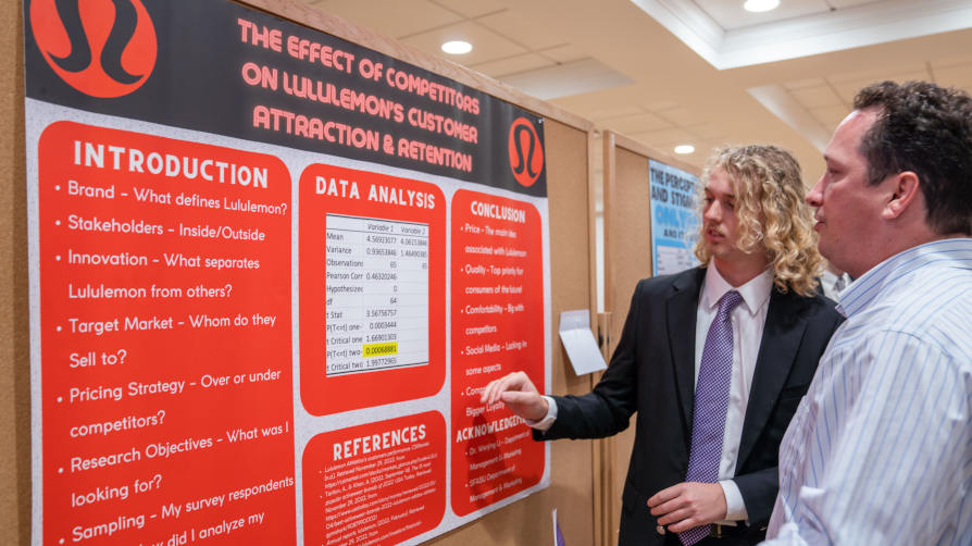A student discussed his research with a faculty member during a poster presentation