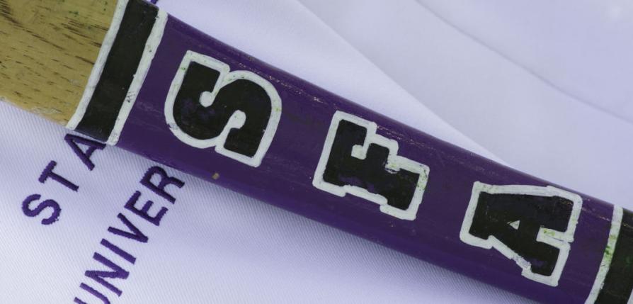 An axe handle with SFA initials placed on top of an SFA logo embroidered shirt