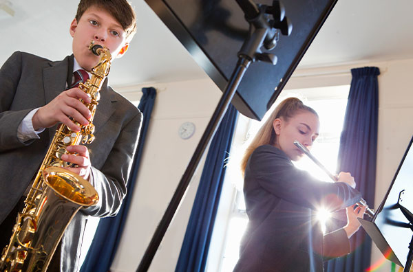 Male student playing saxophone and female student playing flute