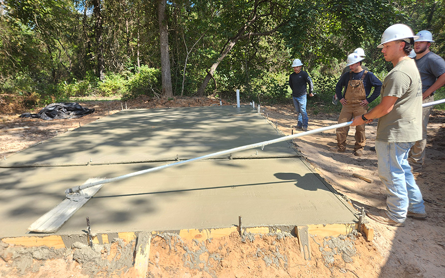 Construction Management students pouring concrete