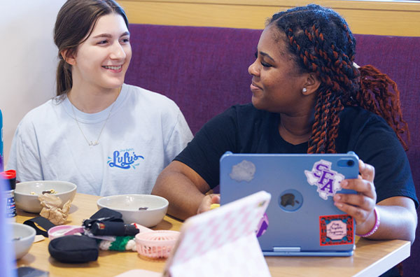 students sitting in booth with laptop