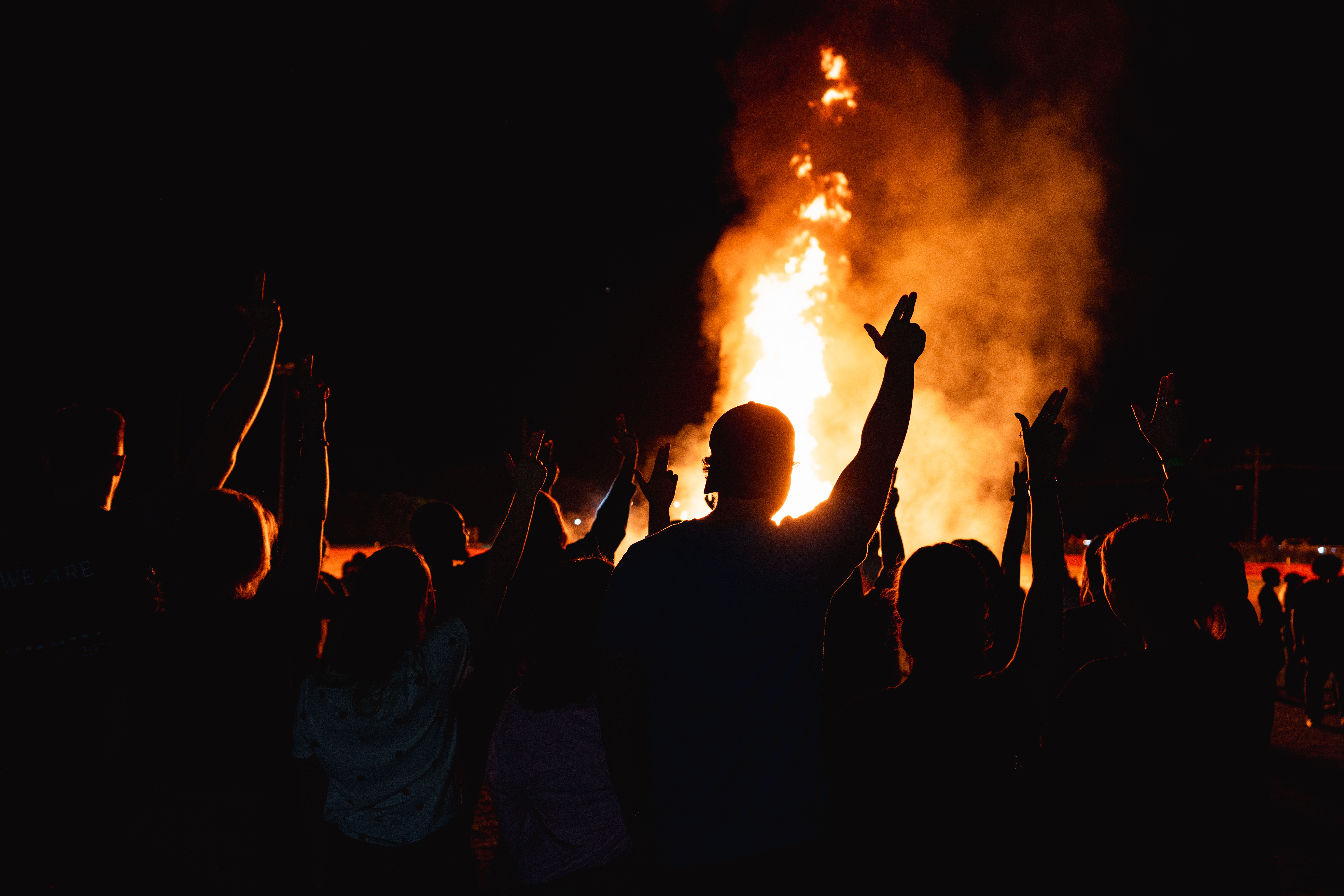 Students at the homecoming bonfire with their Axes up