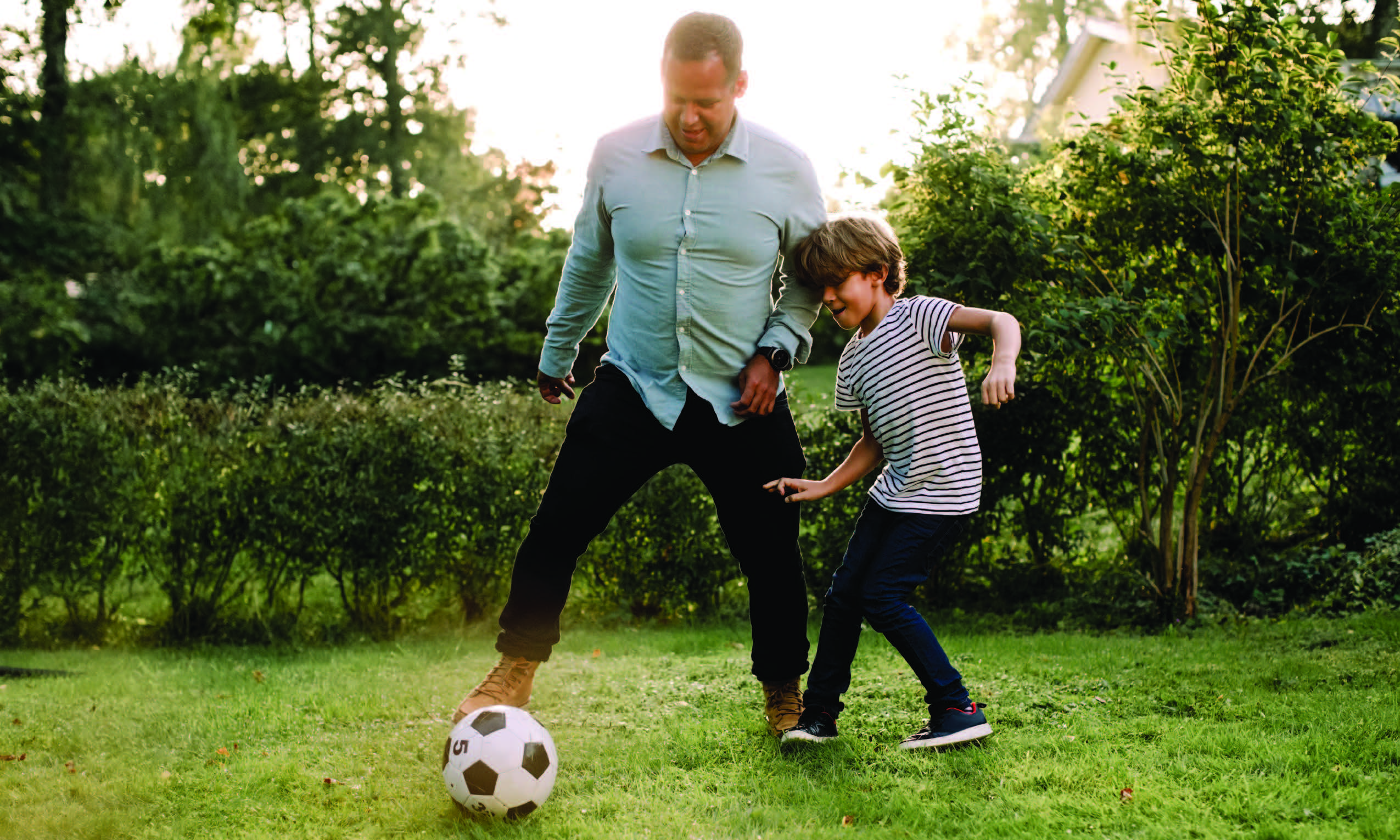 man and boy playing with a soccer ball