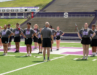 Drum majors practice on a football field