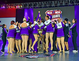 Members of the 2019 national champion dance team celebrate on stage with their trophy. Photo by Hardy Meredith '81