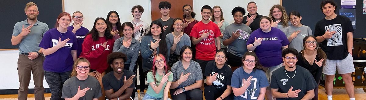 First-generation students posing with smiles and axes up