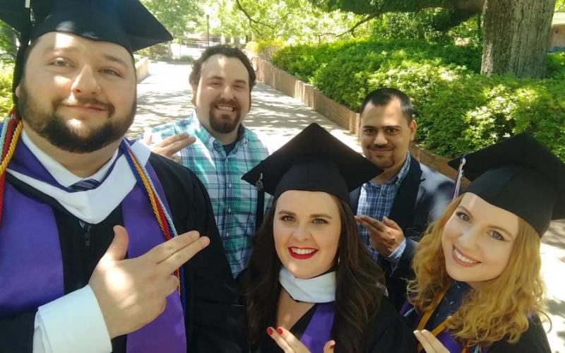SFA history graduates wearing caps and gowns
