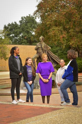 Dr. Michara Delaney-Fields surrounded by a group of students