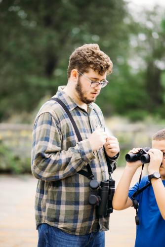 Stephen F. Austin State University student Eamonn Thurmond teaches youth how to use binoculars and shares information about the beautiful birds abundant at the Pineywoods Native Plant Center.