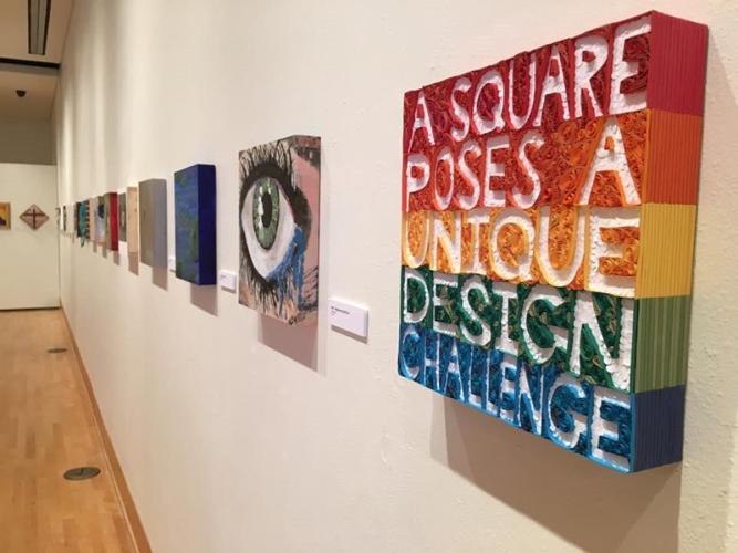 A wall showing artwork featured in the 12x12 scholarship funderaiser