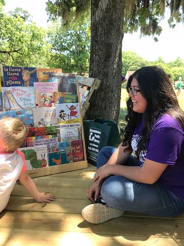 SFA student Ellie Borrego helps a Día de los Libros participant select a book to read.