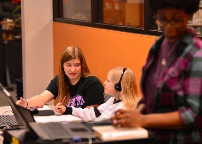 SFA student Jordan Barge helps Ava Adams learn how to code at the Nacogdoches Public Library.