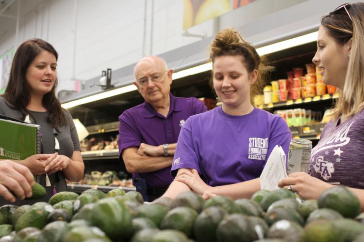 SFA students with faculty and staff members in a grocery store