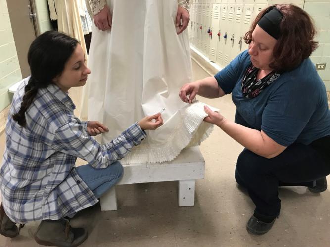 SFA senior Sarah Loveday and graduate student Jessica Tinker apply lace to the wedding dress for the upcoming presentation of Rodgers and Hammerstein’s “Oklahoma!”