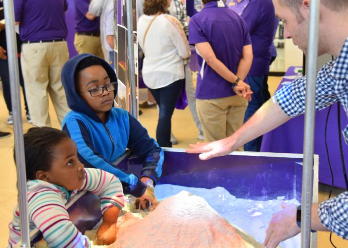 photo of children exploring the augmented reality sand table