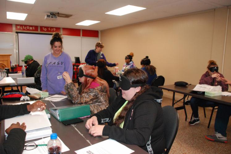 SFA student ShyAnne Stringfellow with employees at the Lufkin State Supported Living Center