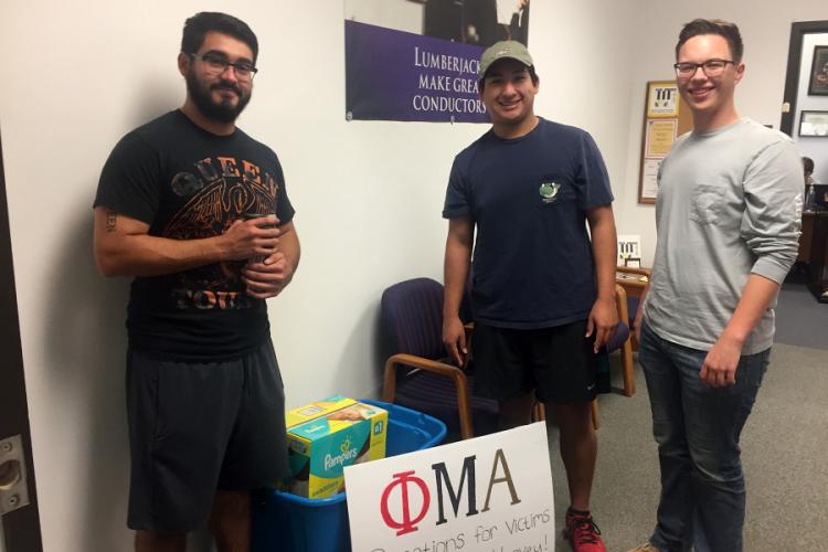 Stephen F. Austin State University students Jacob Rivas, Gregory Garcia, and Kenny Waldrop assisted with collecting donations for storm victims.