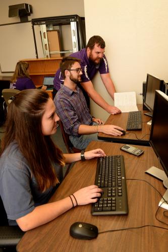 Dr. Brian Barngrover oversees Russell Stager, senior chemistry student, and Alaina Spurr, senior biochemistry student, with their research on latent fingerprinting techniques.