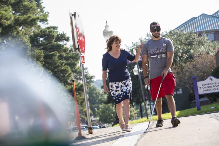 Students learn to use a cane and navigate an area while under blindfold to simulate complete blindness.