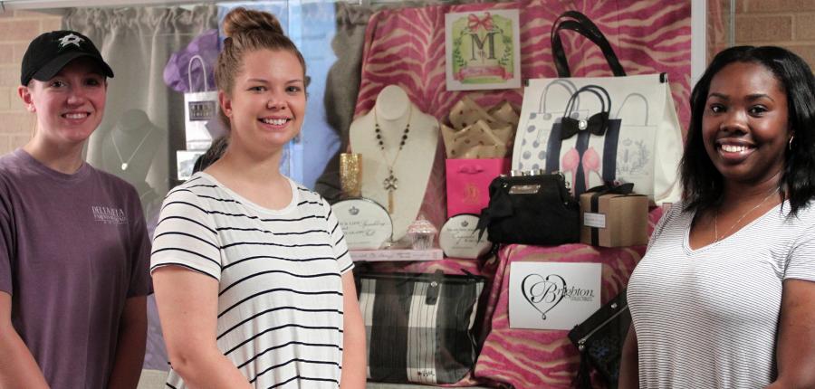 SFA students pictured with display case they designed